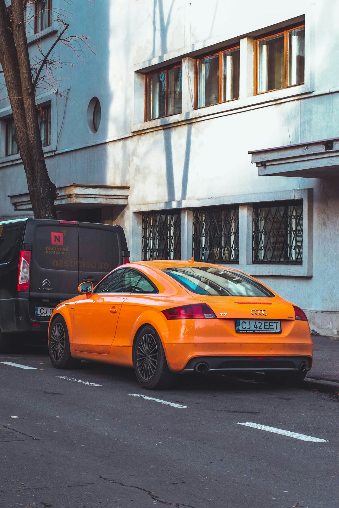 an orange car parked on the side of the road