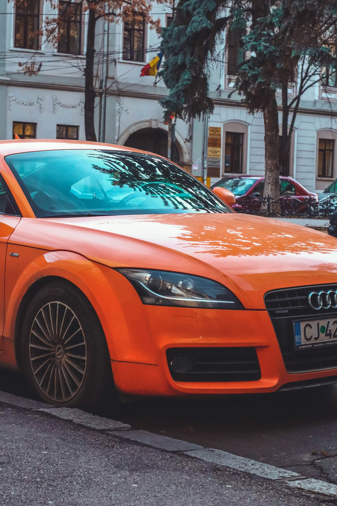 an orange car parked on the side of the road