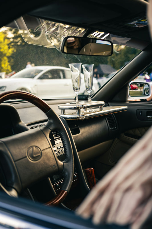 Two champagne glasses inside a car.