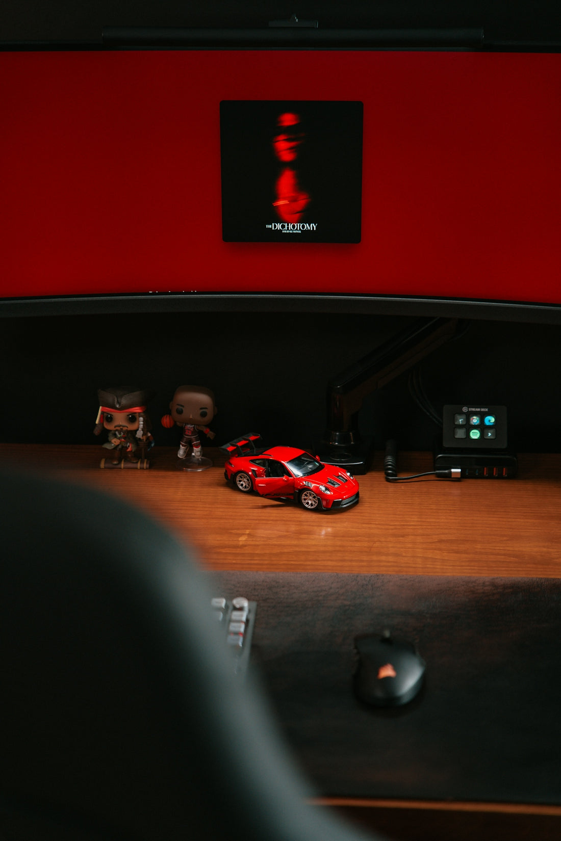 Red toy car on a wooden desk with figures