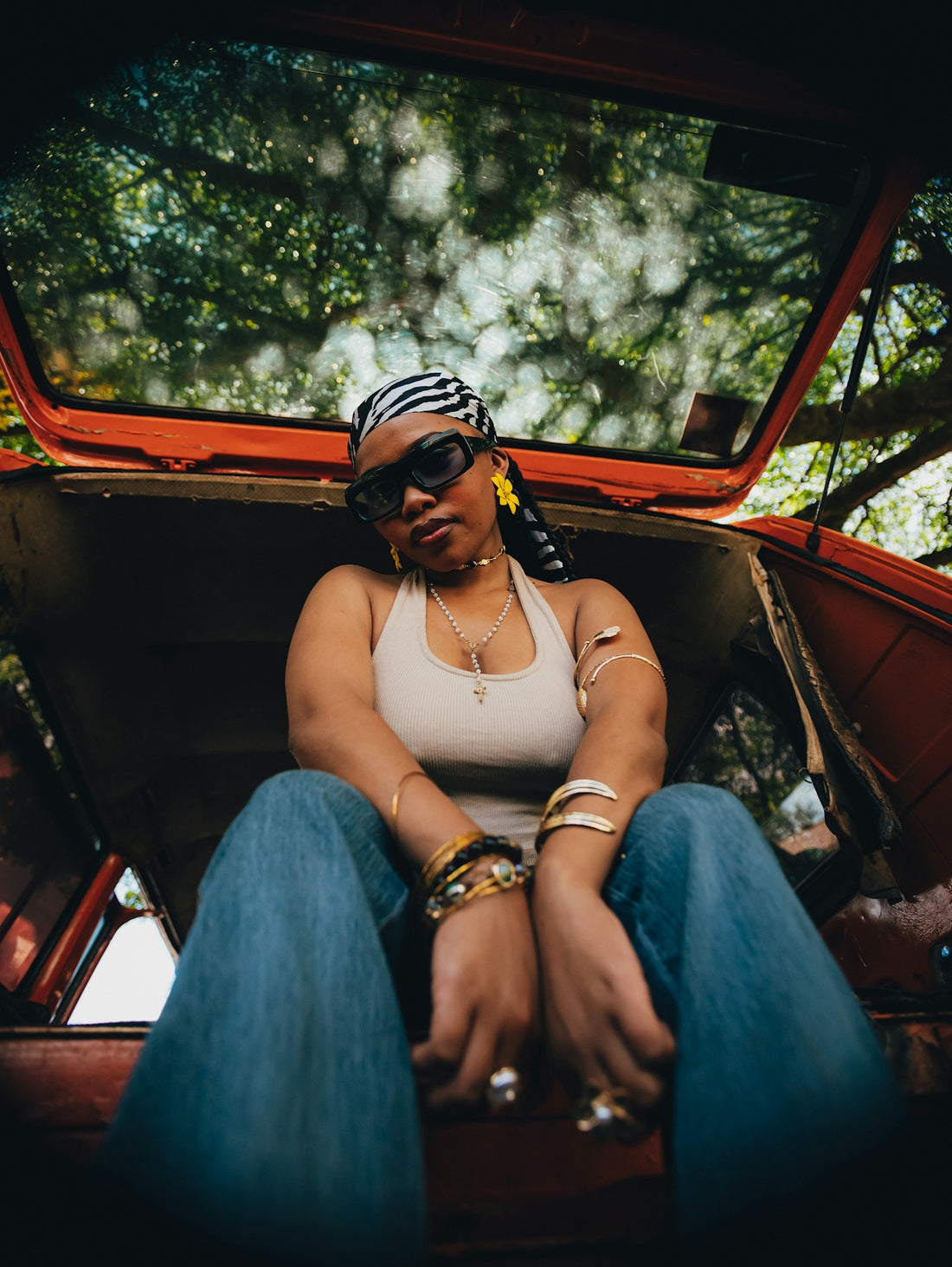 Woman with sunglasses and headscarf sitting in car